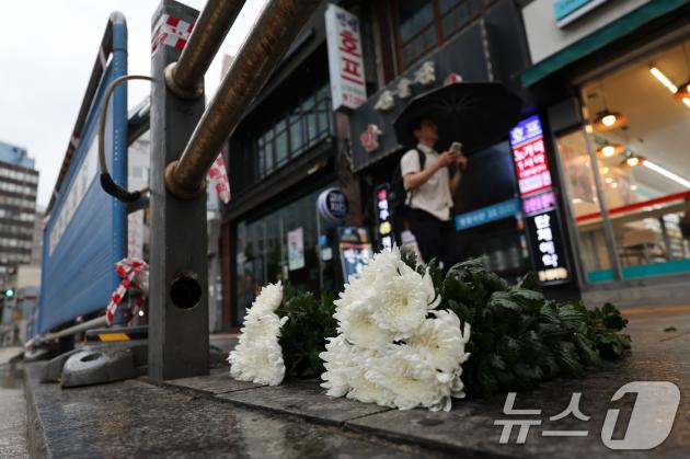 지난밤 승용차가 인도로 돌진해 9명이 사망하는 사고가 발생한 2일 오전 서울 중구 서울시청 인근 교차로 사고현장에 희생자를 추모하는 조화가 놓여 있다.  2024.7.2/뉴스1 ⓒ News1 이재명 기자